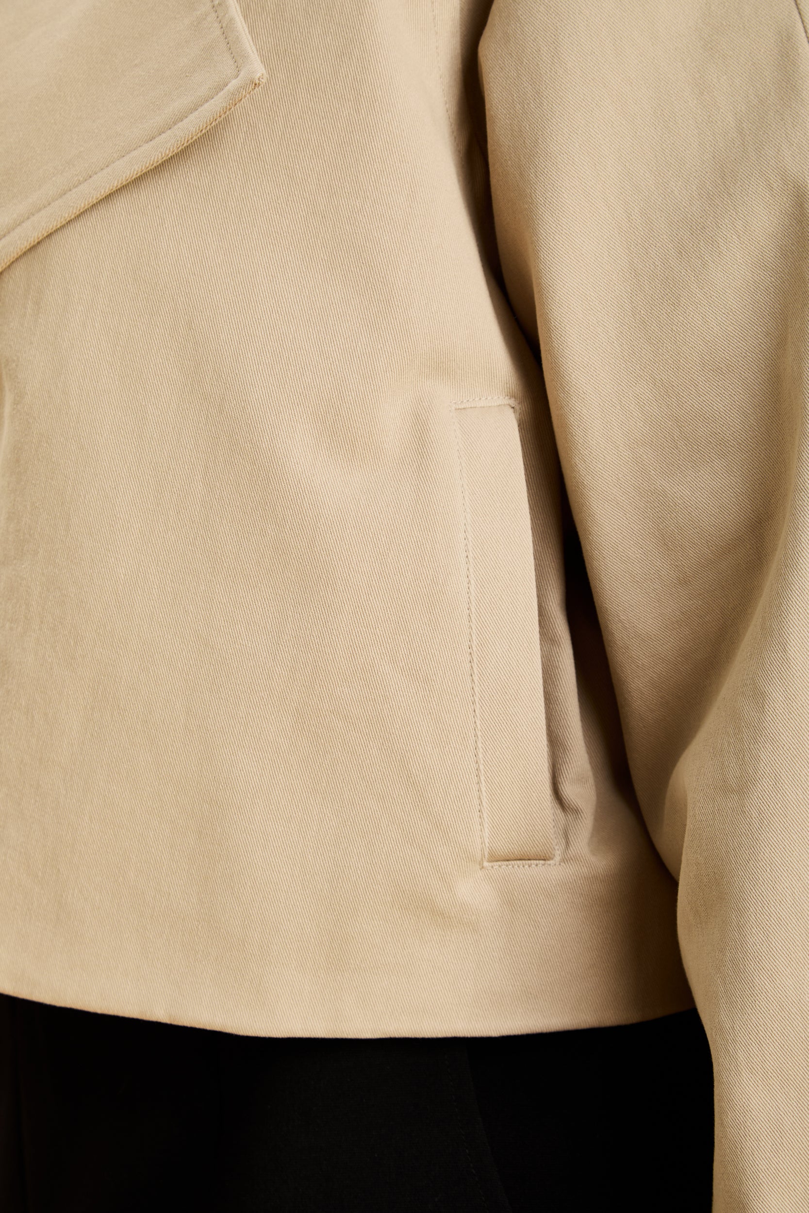 Close-up of a beige jacket with a pocket detail
