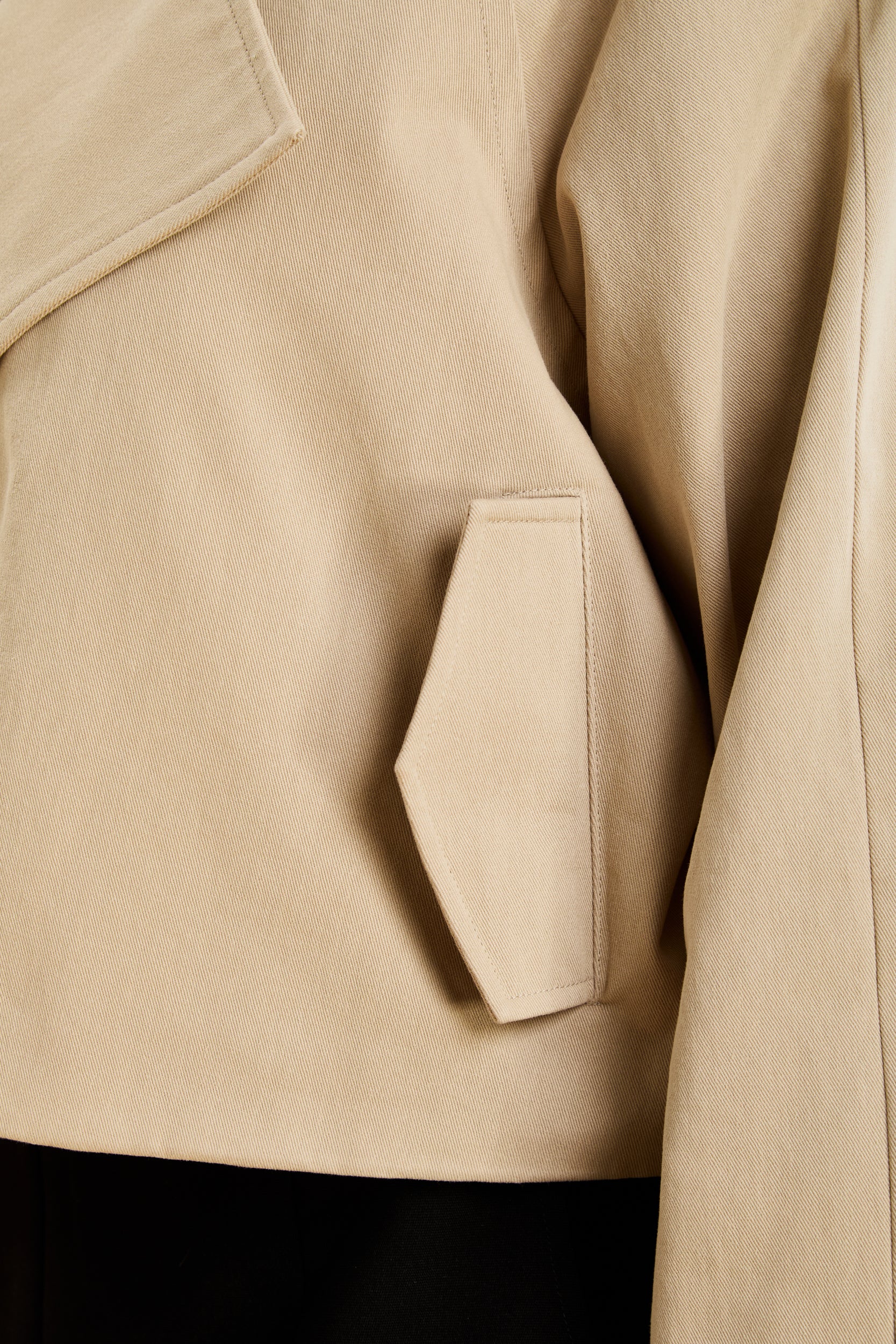 Close-up of a beige coat with a pocket detail