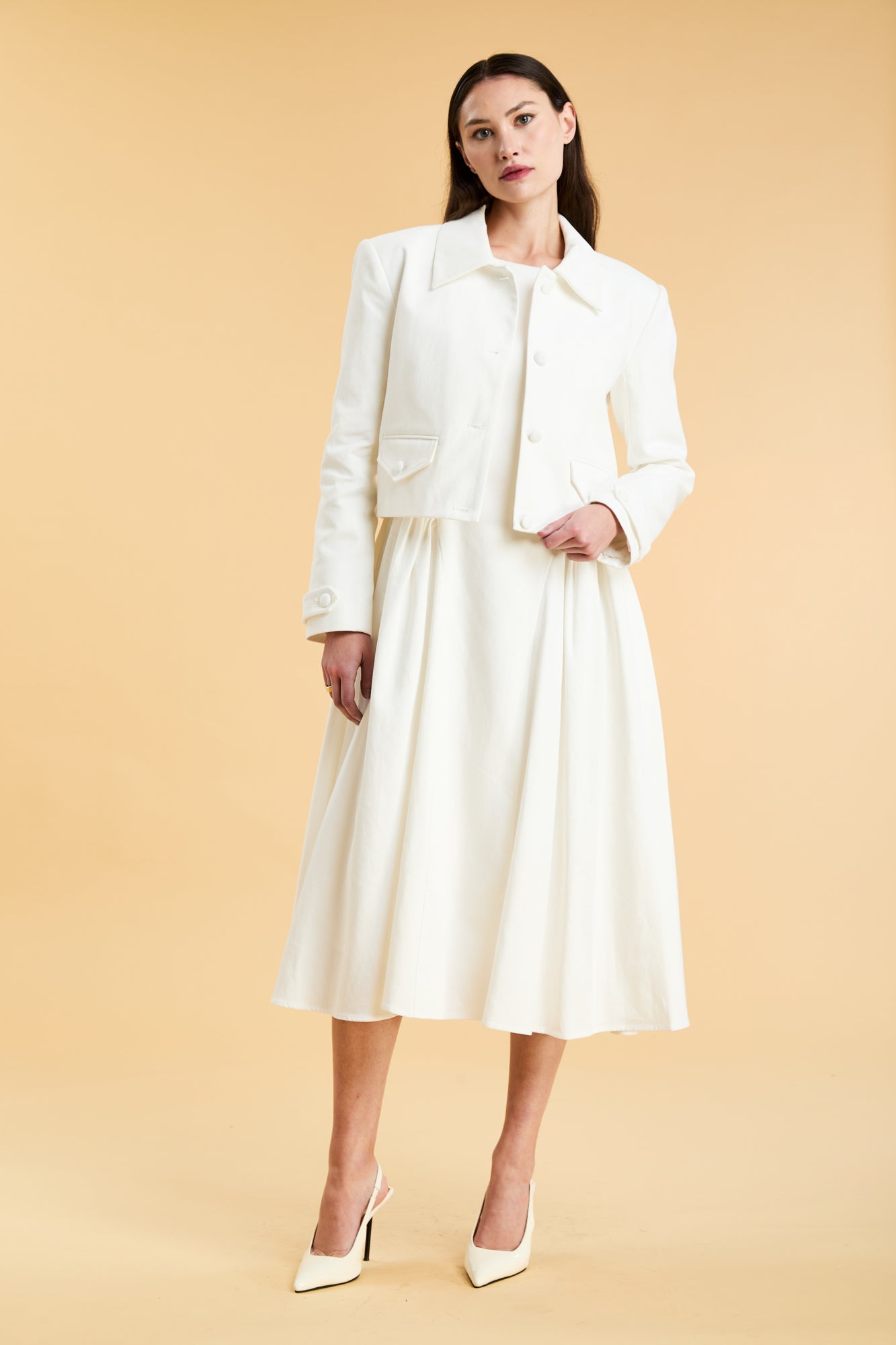 Woman wearing a White Triplicity collared tailored jacket on top of a White Triplicity Eleanor Midi Dress on a beige background front view full body