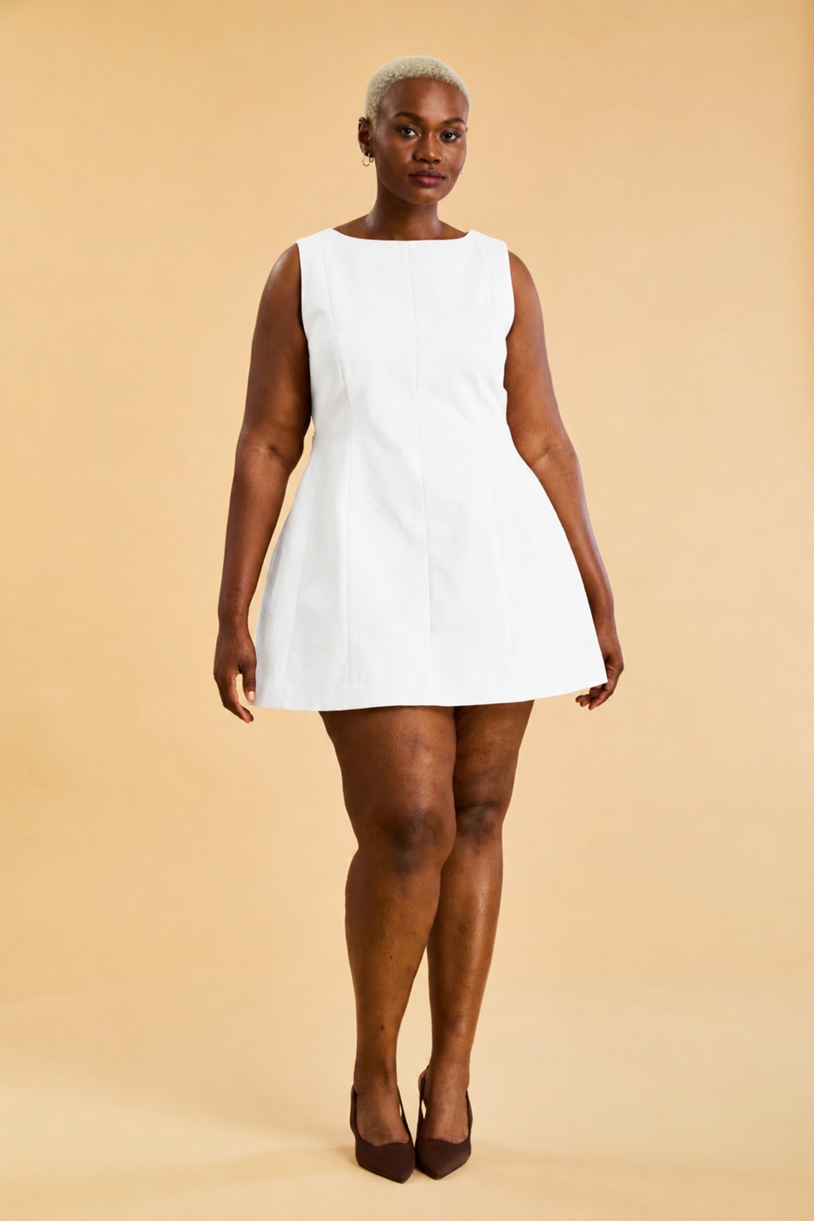 Woman wearing a white sleeveless dress on a beige background
