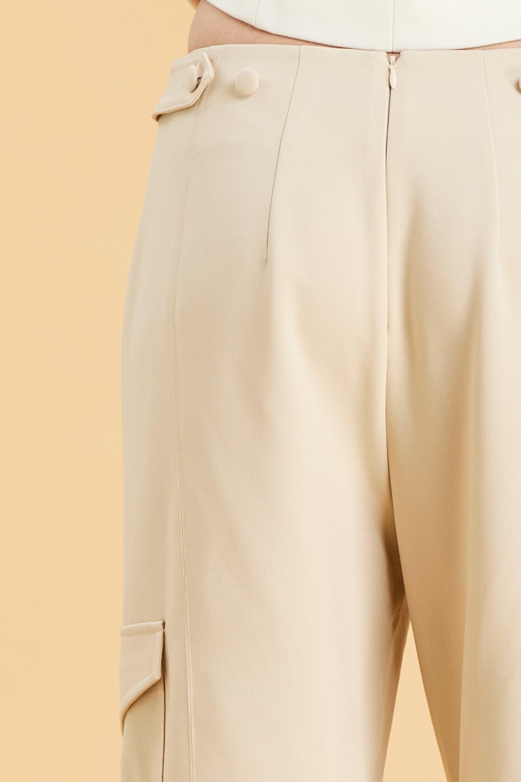Beige pants with a button on a beige background