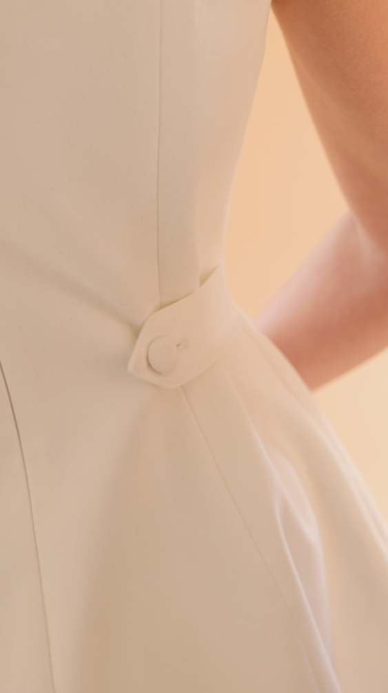 close up of the waist tabs on the White Louise mini dress