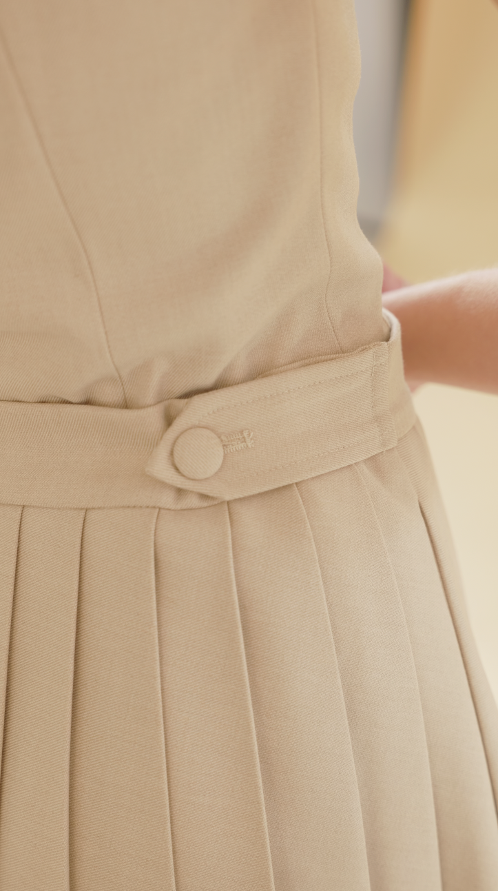 close up of the elisabeth skirt waist tabs adjustable with buttons and hands tighetning and loosening the waist tabs